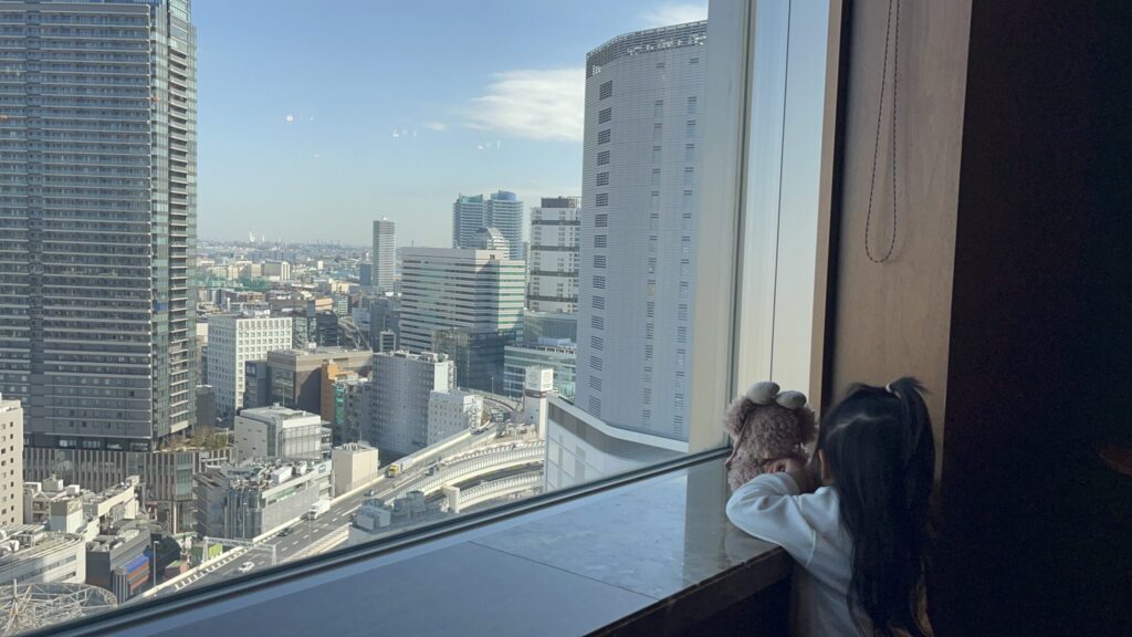 横浜ベイシェラトン ホテル&タワーズ。シェラトンクラブから外の景色を眺める娘・りこと旅のお供シェリーメイ