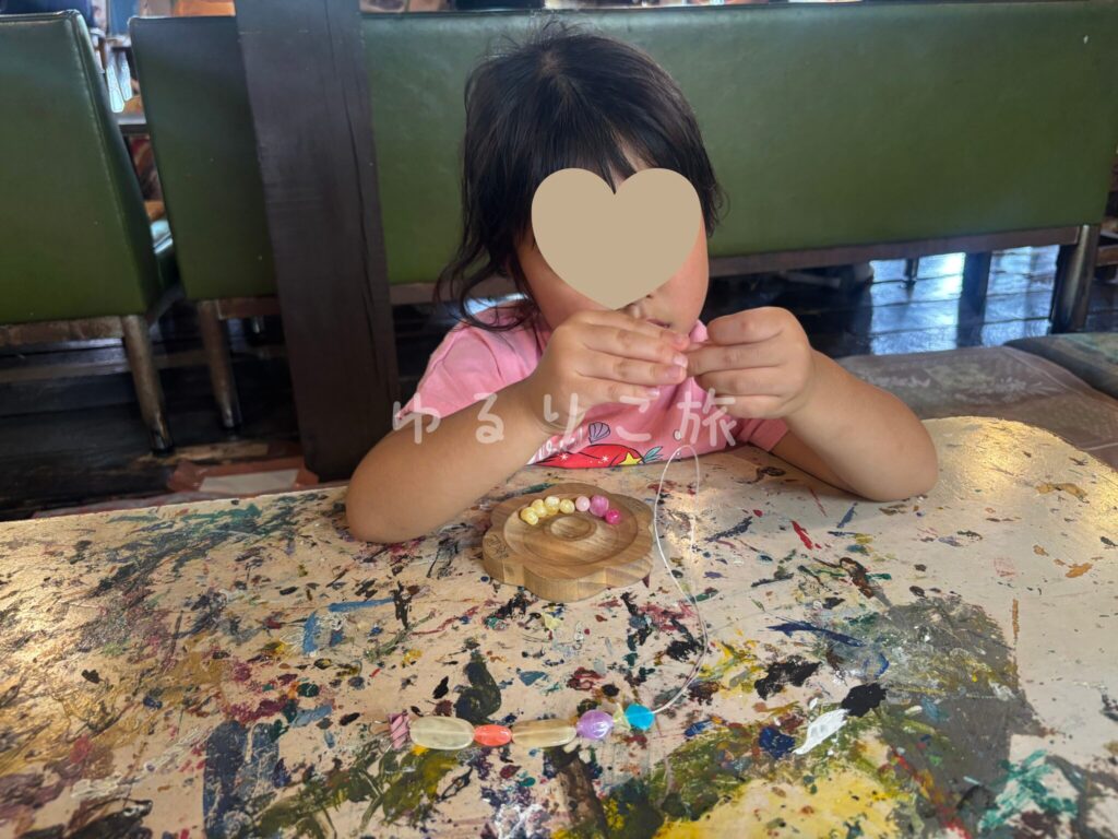 バンコクのArtist's Houseでビーズのブレスレットを作る4歳の娘